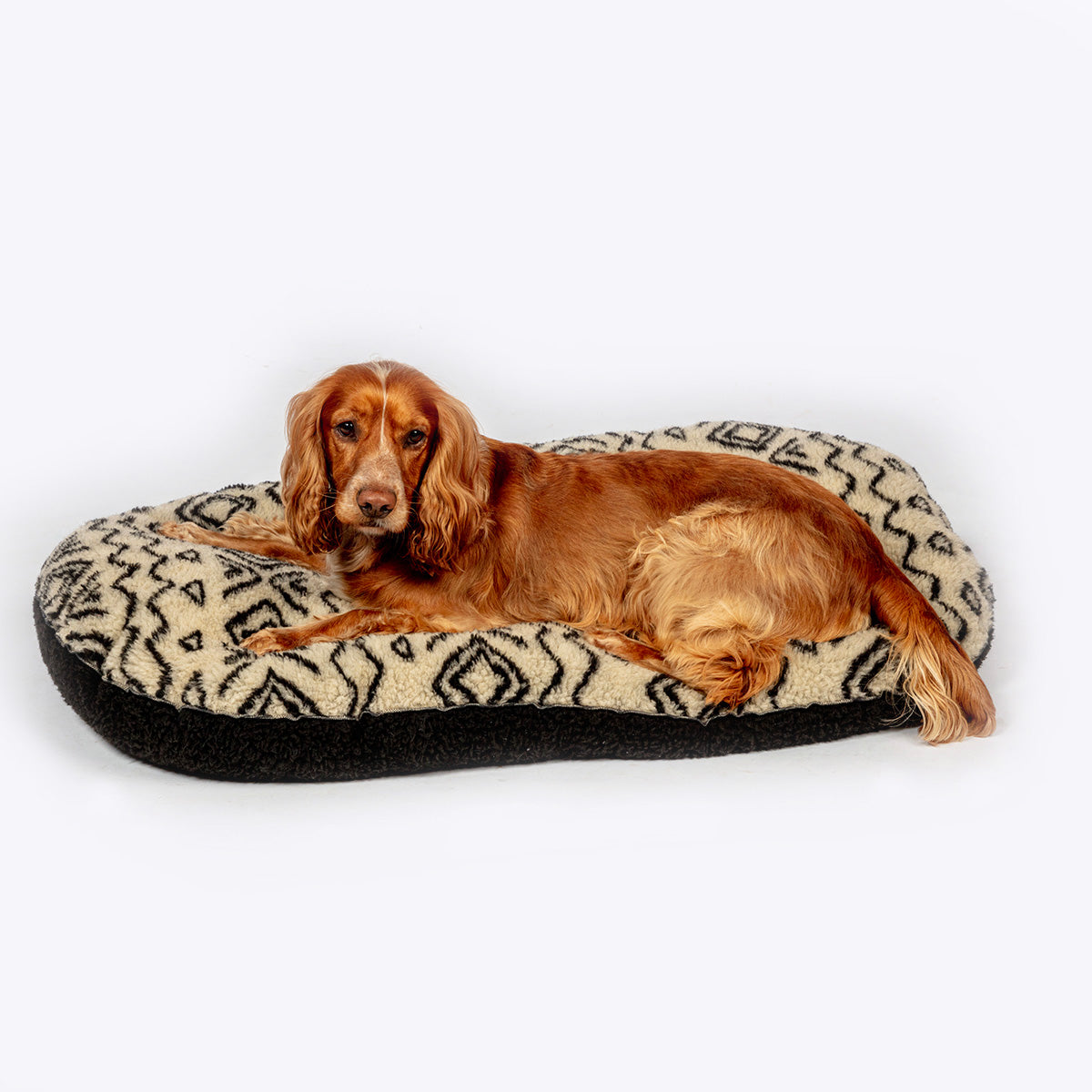 Danish Design Sherpa Fleece Quilted Mattress Dog Bed in Neutral Geometric design with a dog layed on the bed