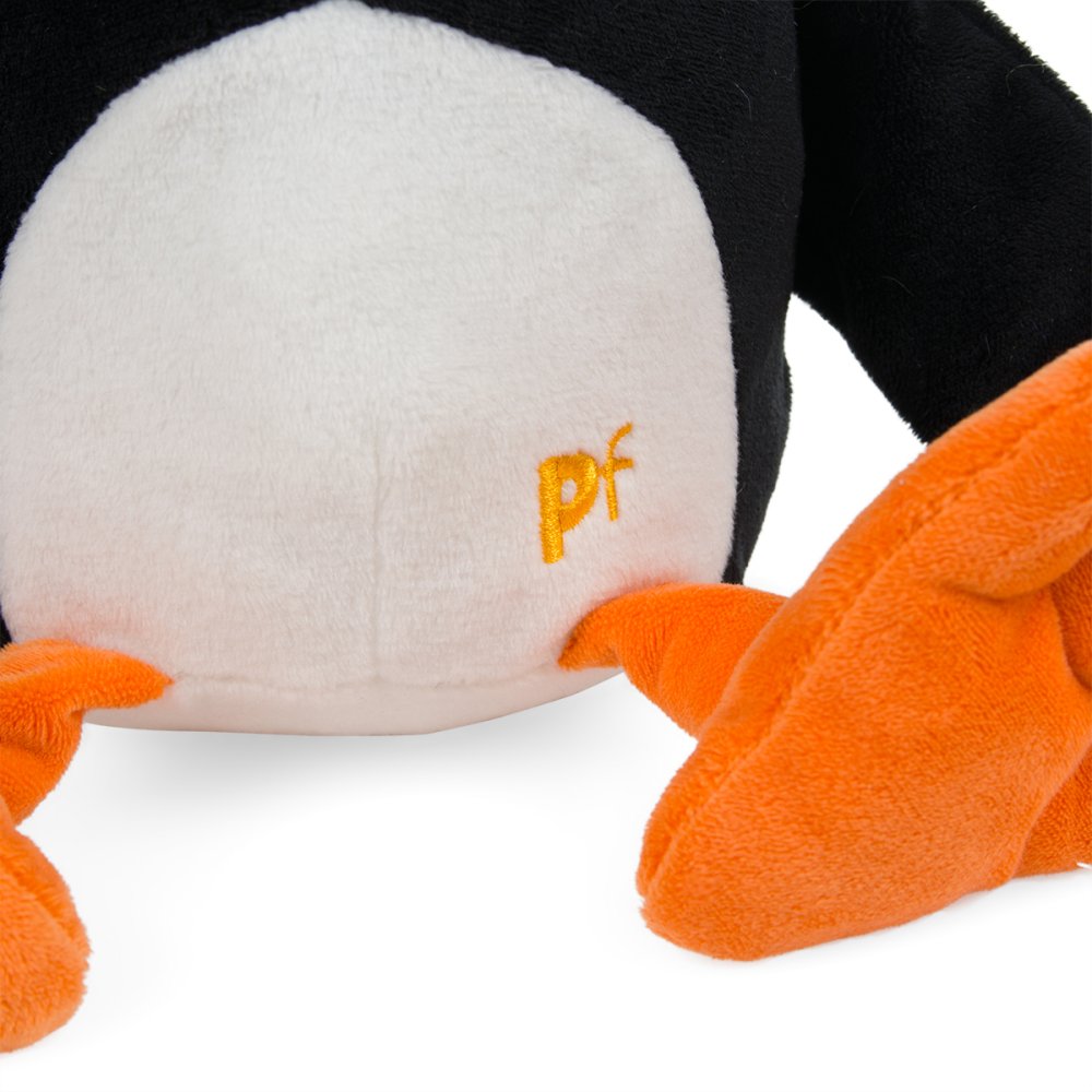 Close-up of a Petface Pana Puffin Plush Dog Toy showing its white belly with an embroidered yellow 'Petface' logo, black head and arm, and bright orange feet